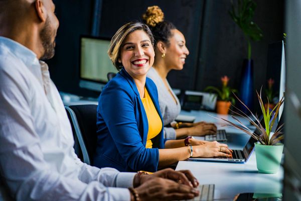 Diverse group of people smiling and looking connected.
